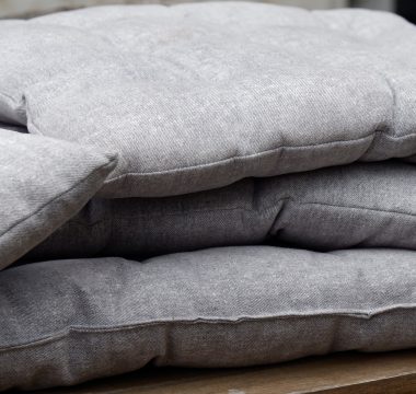 a pile of pillows sitting on top of a wooden table